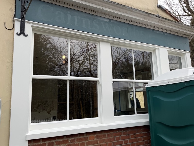 Restored timber shop front window with a painted fascia